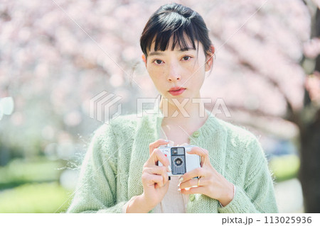 桜の写真を撮る女性 113025936