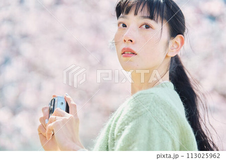 桜の写真を撮る女性 113025962