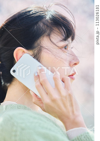 桜の下スマホで通話する女性 桜の下スマホで通話する女性 113026181