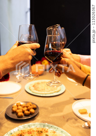 Intimate Toast with Red Wine Over a Shared Meal 113026367
