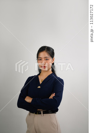 Attractive businesswoman standing with arms crossed and looking at camera confidently Attractive businesswoman standing with arms crossed and looking at camera confidently 113027172