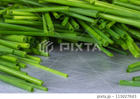 Green chopped chives on kitchen metal table 113027683