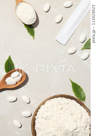 Collagen in powder and tablets with a wooden spoon 113028023