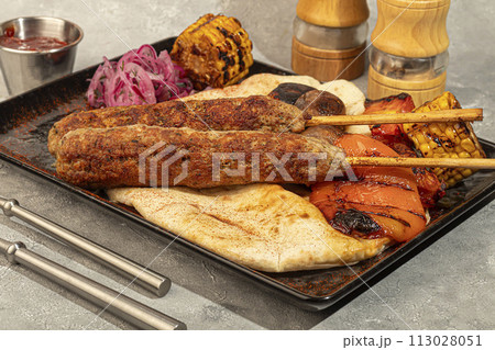 Lamb cutlet with grilled vegetables and lavash. Red onion and corn. Lamb cutlet with grilled vegetables and lavash. Red onion and corn. 113028051