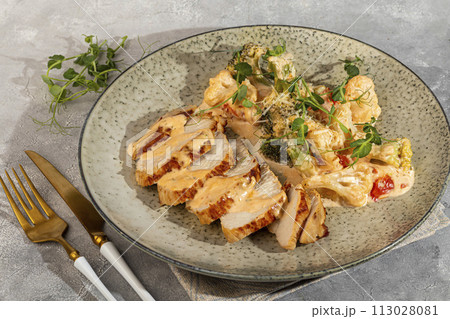 Grilled chicken breast sliced with stewed cauliflower and white sauce. Grilled chicken breast sliced with stewed cauliflower and white sauce. 113028081