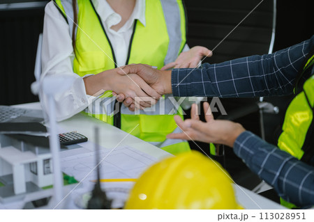 architects and engineers shake hands while working for teamwork and cooperation after completing an agreement in an office facility, successful cooperation concept. architects and engineers shake hands while working for teamwork and cooperation after completing an agreement in an office facility, successful cooperation concept. 113028951