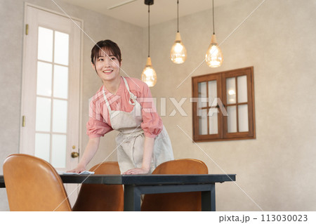 テーブルを掃除する女性アルバイトスタッフ 113030023