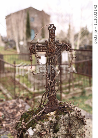 Abandoned grave with a rusty cross in a cemetery 113032142