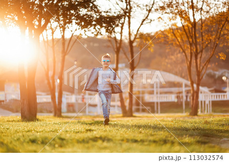 Smiling boy runs through the autumn park. Copy space. Concept of happy childhood 113032574