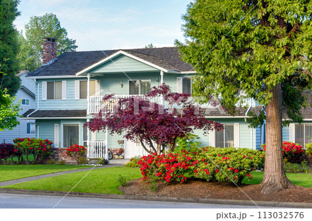 Big family residential house with landscaped front yard and trees Big family residential house with landscaped front yard and trees 113032576