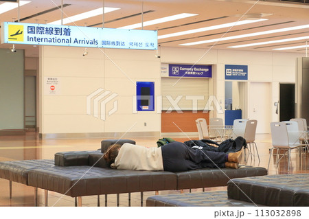 空港のベンチで仮眠する外国人旅行客　羽田空港のインバウンド 113032898