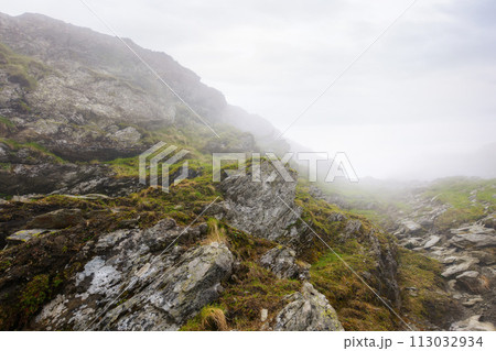 romanian countryside scenery on a foggy day. mountainous nature landscape with steep rocky hills. extreme summer vacations in fagaras romanian countryside scenery on a foggy day. mountainous nature landscape with steep rocky hills. extreme summer vacations in fagaras 113032934
