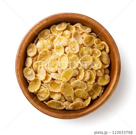 Corn flakes in a wooden plate close-up on a white. Top view 113033708