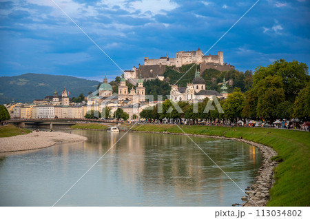 Salzburg, Austria, August 15, 2022. Golden hour shot towards the historic center. Highlighted is the fort at the top of the hill which dominates the landscape. Salzburg, Austria, August 15, 2022. Golden hour shot towards the historic center. Highlighted is the fort at the top of the hill which dominates the landscape. 113034802