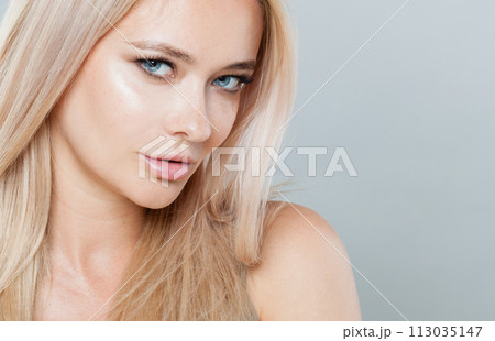 Charming woman face close-up. Blonde model with fresh clear skin and healthy silky hair  113035147