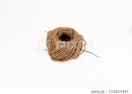 a ball of coarse thread highlighted on a white background a ball of coarse thread highlighted on a white background 113035481