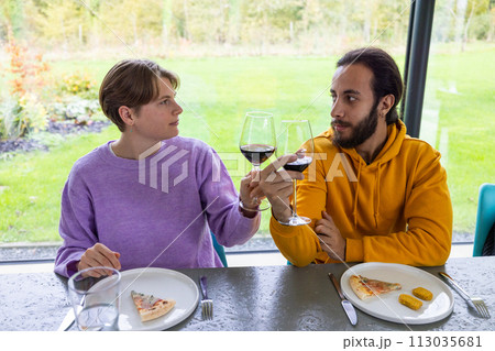Meaningful Glances: Two Friends Sharing Wine and Insights 113035681