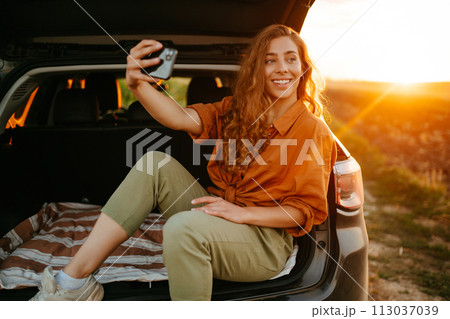 Selfie time. Woman takes selfie in car during road trip. Lifestyle, travel, tourism, active life. 113037039