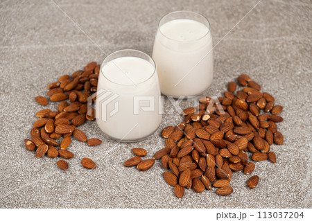 Almond nut milk in a glasses on a gray background. Almond nut milk in a glasses on a gray background. 113037204