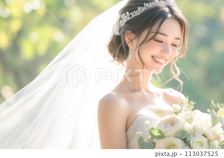 ブーケを持つウェディングドレス姿の笑顔の花嫁 113037525