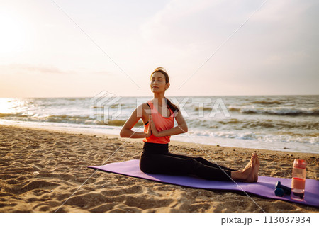 Young woman in sportswear doing yoga, fitness exerciseon the beach. Sport, Active life. 113037934