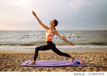 Young woman in sportswear doing yoga, fitness exerciseon the beach. Sport, Active life. Young woman in sportswear doing yoga, fitness exerciseon the beach. Sport, Active life. 113037939