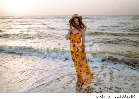 Stylish woman in elegant dress posing near the sea. Summer time. Travel, weekend, relax. 113038594