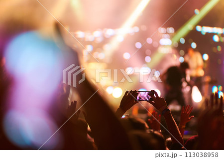 Hand with a phone records live music festival. People taking photographs with smart phone during concert. 113038958