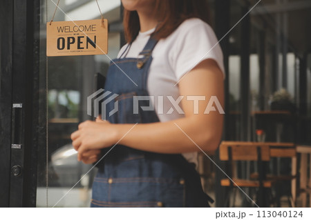 Startup successful small business owner sme beauty girl stand with tablet smartphone in coffee shop restaurant. Portrait of asian tan woman barista cafe owner. SME entrepreneur seller business concept 113040124
