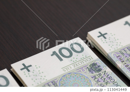 Banknotes evenly distributed on a dark brown desk ready for use. 113041449