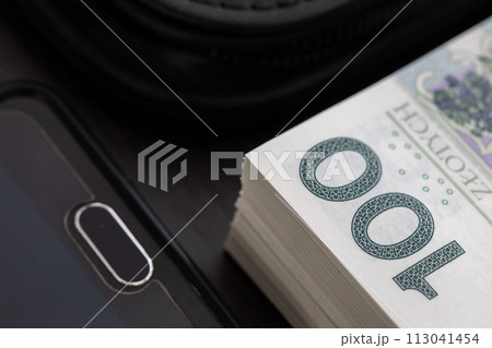 Polish paper banknotes with a face value of PLN 100 are the official currency of the country and are on the table. 113041454