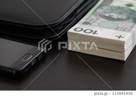 Polish paper banknotes with a face value of PLN 100 are the official currency of the country and are on the table. 113041456