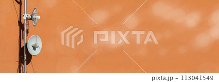Two telecommunications antennas used for cellular network and wireless Internet, fixed on the building wall. Receiving and digitizing multiple pieces of information at once. Panoramic frame. Bokeh 113041549