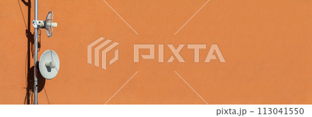 Two telecommunications antennas used for cellular network and wireless Internet, fixed on the building wall. Receiving and digitizing multiple pieces of information at once. Panoramic frame. 113041550