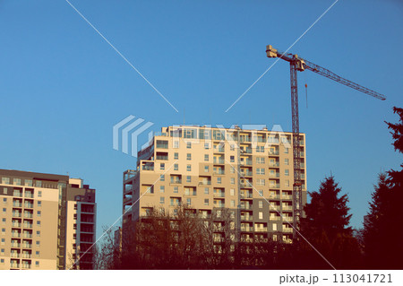 A high multi-family apartment block against a blue sky. A high multi-family apartment block against a blue sky. 113041721