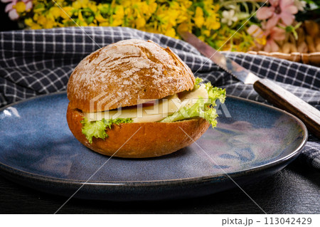 Roll with cheese and lettuce. 113042429