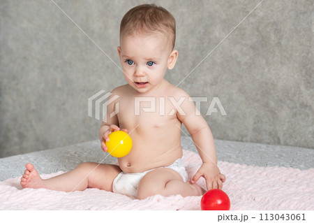 The child froze in delight and throws away the colored balls he is playing with 113043061