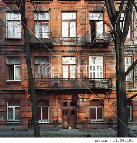 Tall Brick Building With Many Windows and Balconies 113043196