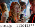 Woman Looking at Cell Phone Next to Man. June 30, Social Media Day 113043277