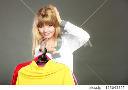 woman customer holding hangers with clothes woman customer holding hangers with clothes 113043325