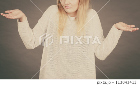 Confused young blonde woman gesturing with hands Confused young blonde woman gesturing with hands 113043413