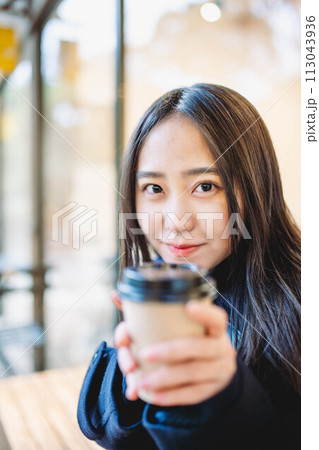 ベンチに座り飲み物を飲む女子高生 ベンチに座り飲み物を飲む女子高生 113043936