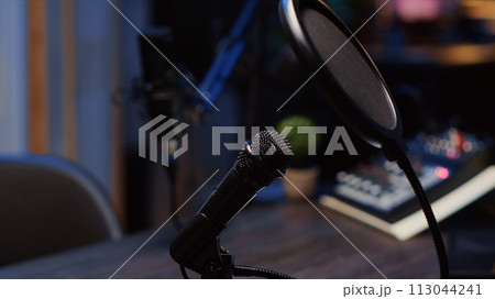 Zoom out shot of podcast microphone used to record conversations with impeccable sound quality for internet show. Close up shot of audio capturing and recording technology 113044241