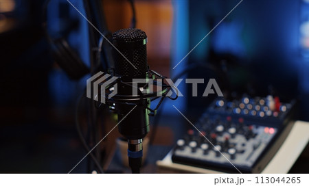Close up shot of professional microphone used to record podcast conversations for online livestreaming channel. High quality sound capturing and recording gear in apartment studio 113044265