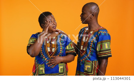Tired husband and wife dealing with migraine on camera, being in pain and rubbing temples to ease tension. African american married couple feeling sick with painful headache, overworked. 113044301