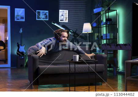 Maniac fan enjoying seeing favorite team win while watching live sports event broadcasted on TV. Overjoyed supporter depleted of energy after celebrating club getting victory in football competition Maniac fan enjoying seeing favorite team win while watching live sports event broadcasted on TV. Overjoyed supporter depleted of energy after celebrating club getting victory in football competition 113044402