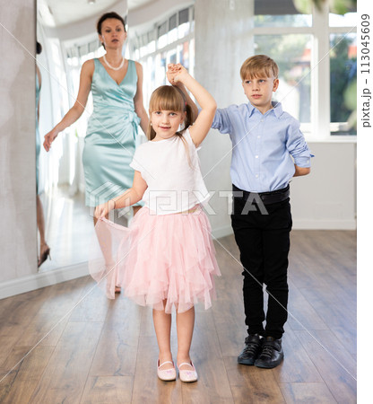 Boy and girl in pair train to dance contemporary vigorous waltz during classes. 113045609