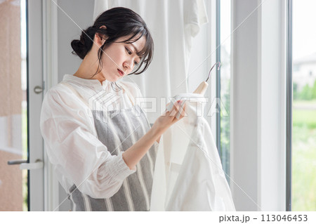 洗濯物のシャツの襟元の汚れに悩む主婦の女性（黄ばみ・漂白剤・洗剤・汗ジミ・汚れ） 113046453