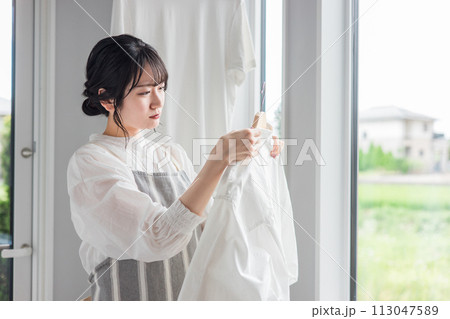 洗濯物のシャツの襟元の汚れに悩む主婦の女性（黄ばみ・漂白剤・洗剤・汗ジミ・汚れ） 113047589
