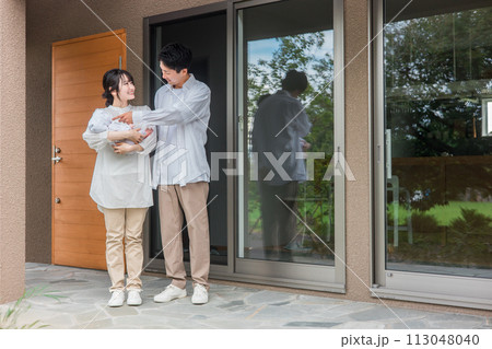 新築のマイホーム・一軒家・一戸建ての玄関の前に立つ施主の夫婦と赤ちゃん・カップル・家族 新築のマイホーム・一軒家・一戸建ての玄関の前に立つ施主の夫婦と赤ちゃん・カップル・家族 113048040